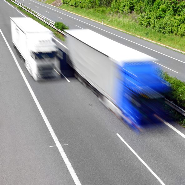 Motion blurred trucks on highway.