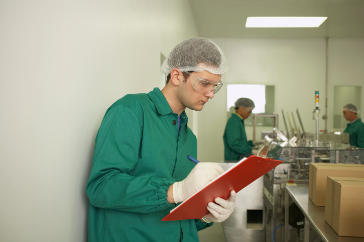 Lab technician writing on clipboard